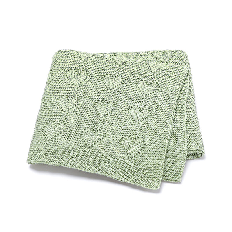 Issy & Lilo organic cotton blanket in green, featuring a delicate heart-knit pattern