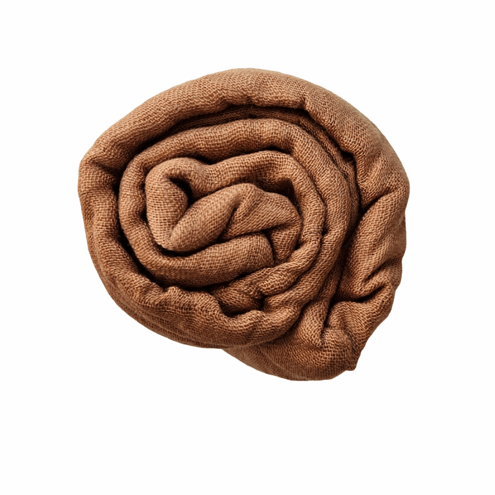 A neatly folded milk chocolate bamboo swaddle blanket, coiled into a compact, circular shape. The blanket appears soft and breathable, showcasing its lightweight and comfortable texture ideal for newborns.