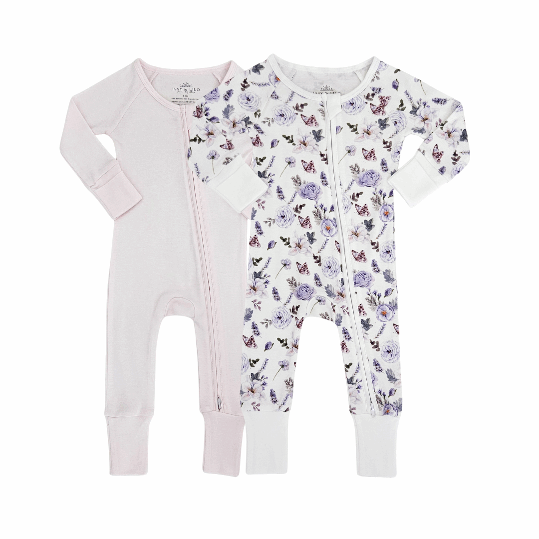 Two bamboo zipper rompers for babies, one in solid beige and the other with a colorful floral print, designed for comfort and easy diaper changes.