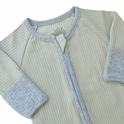 Smart organic cotton zipper romper in sage green with contrasting sky blue cuffs and zipper detail, providing a soft, breathable, and easy-to-wear design for babies.