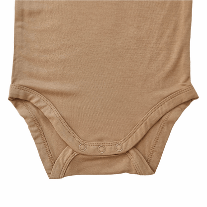 close-up of the bottom part of a mustard bamboo baby bodysuit with snap buttons